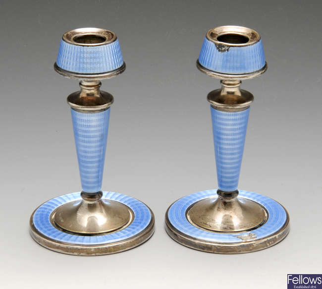 A pair of 1920's silver and enamel candlesticks.