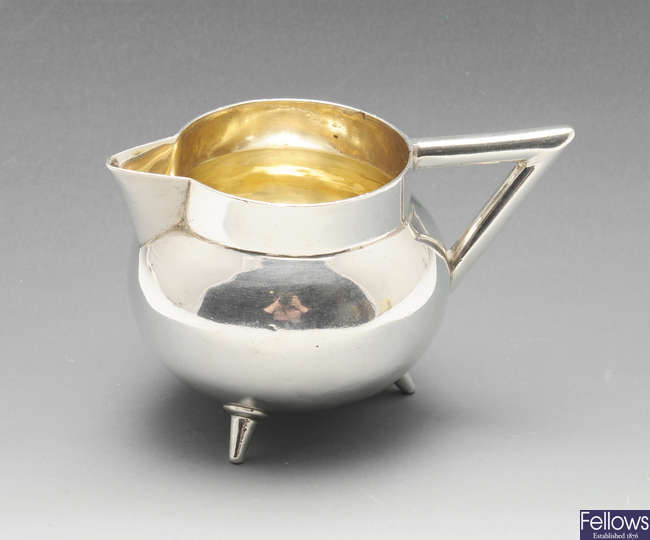 A small Victorian silver cream jug in Arts & Craft style.