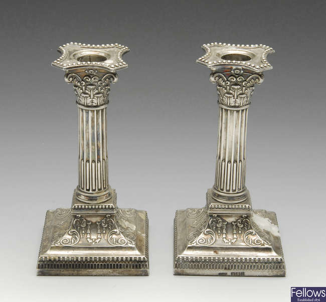 A pair of late Victorian Corinthian candlesticks.
