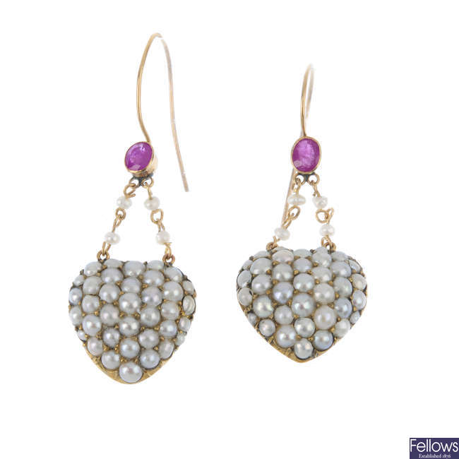 A pair of pearl heart earrings.