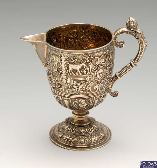 A Victorian silver pedestal cream jug with chased decoration.