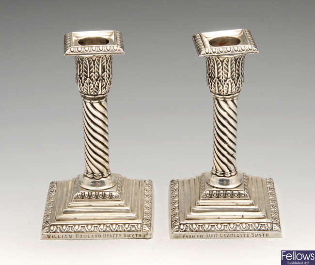 A pair of late Victorian silver mounted candlesticks.