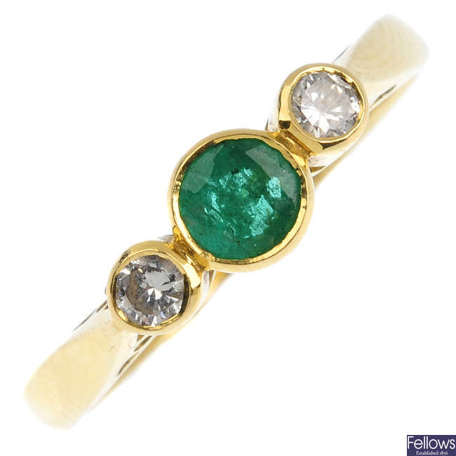 An 18ct gold emerald and diamond three-stone ring. 