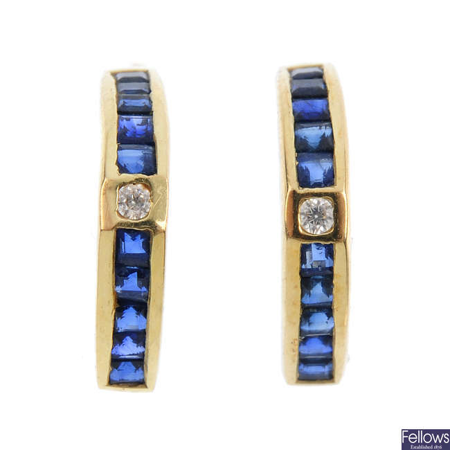 A pair of sapphire and diamond hoop earrings.