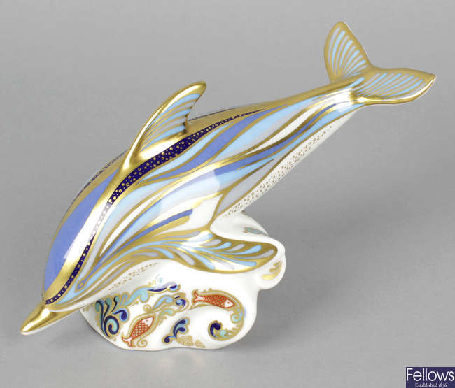 A Royal Crown Derby porcelain paperweight modelled as a striped dolphin.