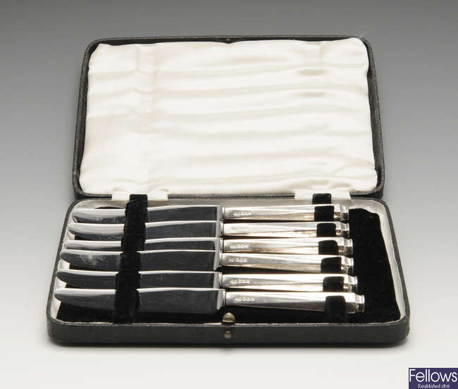 A cased set of silver-handled tea knives, a silver napkin ring, assorted silver spoons, sugar tongs & a small quantity of plated flatware.