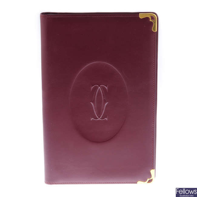 CARTIER - a Must De Cartier Bordeaux leather writing cover with inserts.