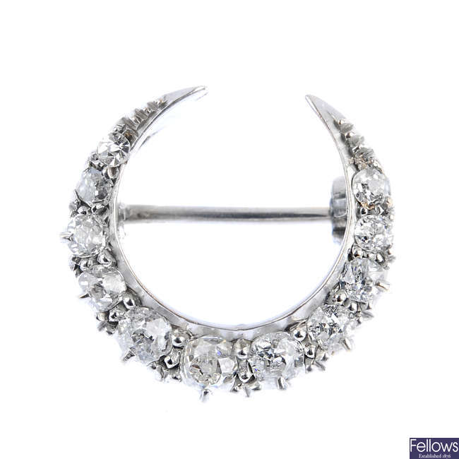 An early 20th century gold diamond crescent brooch.