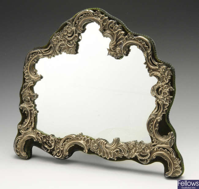 An Edwardian silver mounted easel back mirror of asymmetrical form.