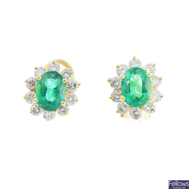 A pair of emerald and diamond cluster earrings.