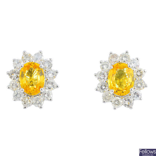 A pair of yellow sapphire and diamond cluster earrings.