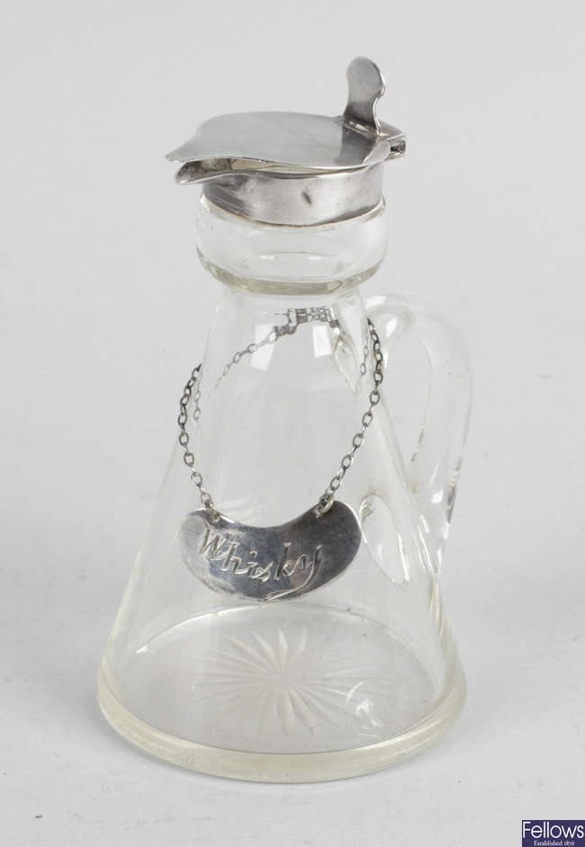 An early George V silver mounted glass whisky noggin and wine label.