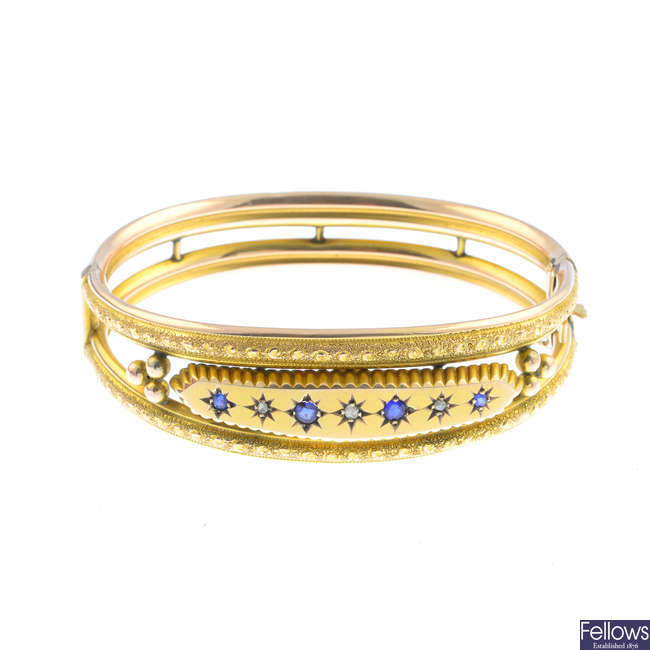 An Edwardian 9ct gold diamond and blue gem hinged bangle.