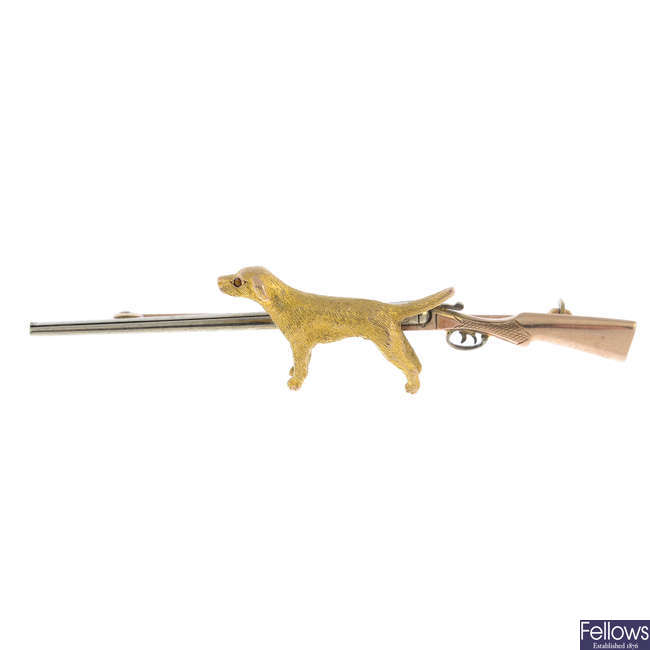 An early 20th century gold rifle and dog hunting theme bar brooch.