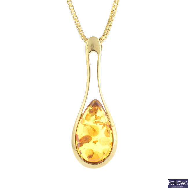 A 14ct gold modified amber pendant, with a 14ct gold chain.