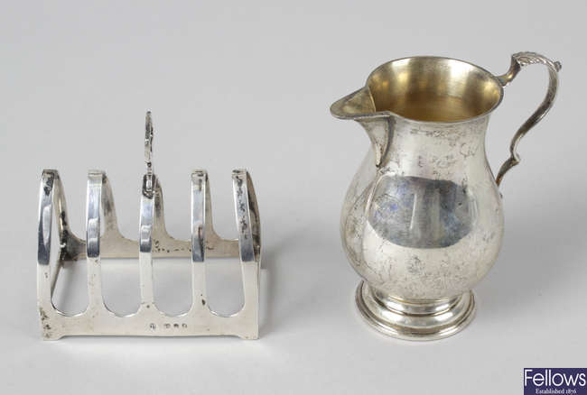 A 1930's small silver toast rack & a modern silver cream jug. (2). 