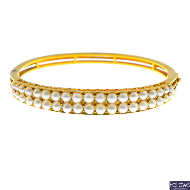 An early 20th century gold split pearl hinged bangle.