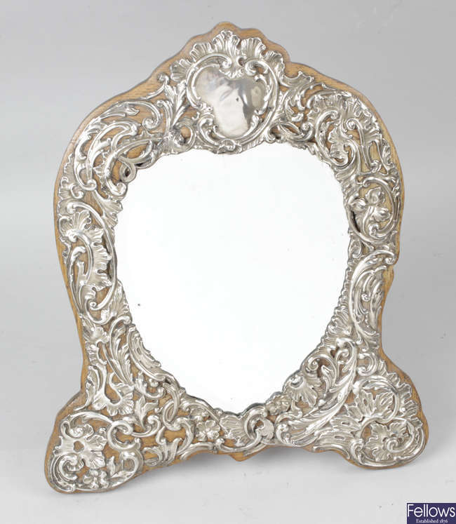 An Edwardian silver mounted heart shape mirror with easel back.