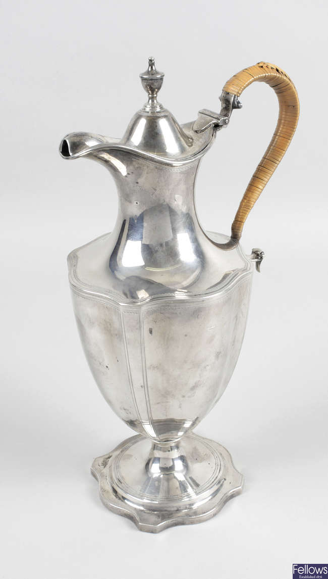 A George III silver lidded jug with wicker bound handle.