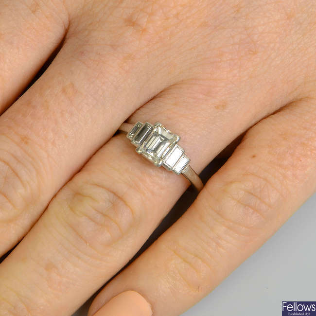 A rectangular-shape diamond single-stone ring, with baguette-cut diamond stepped shoulders.