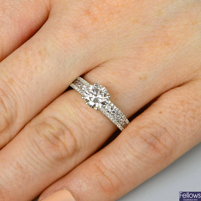 A platinum brilliant-cut diamond single-stone ring, with similarly-cut diamond line sides.