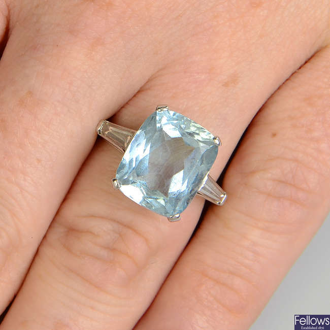 An aquamarine single-stone ring, with tapered baguette-cut diamond shoulders.