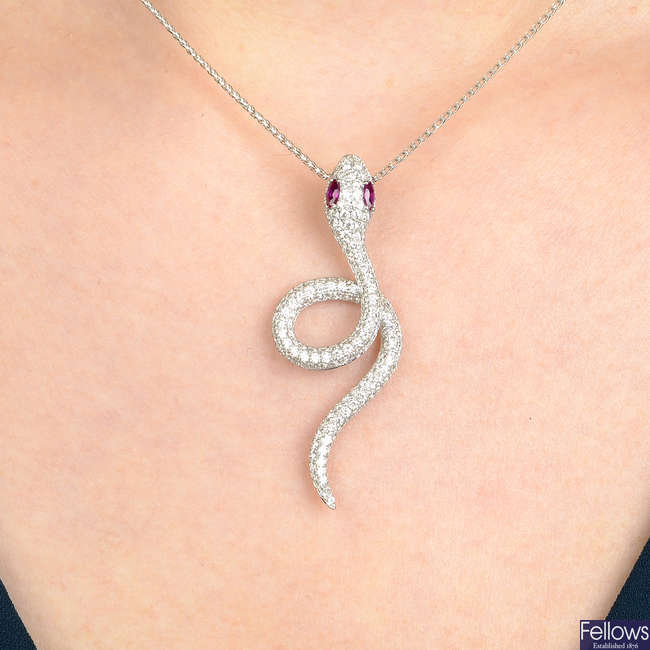 An 18ct gold pave-set diamond snake pendant, with ruby eyes, on fancy-link chain.
