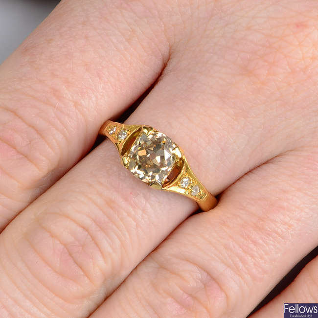 An old-cut brown diamond single-stone ring, with diamond shoulders.