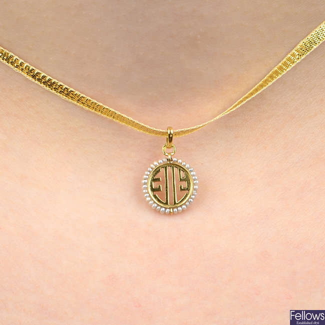 An early 20th century 18ct gold seed pearl pendant charm, by Cartier.