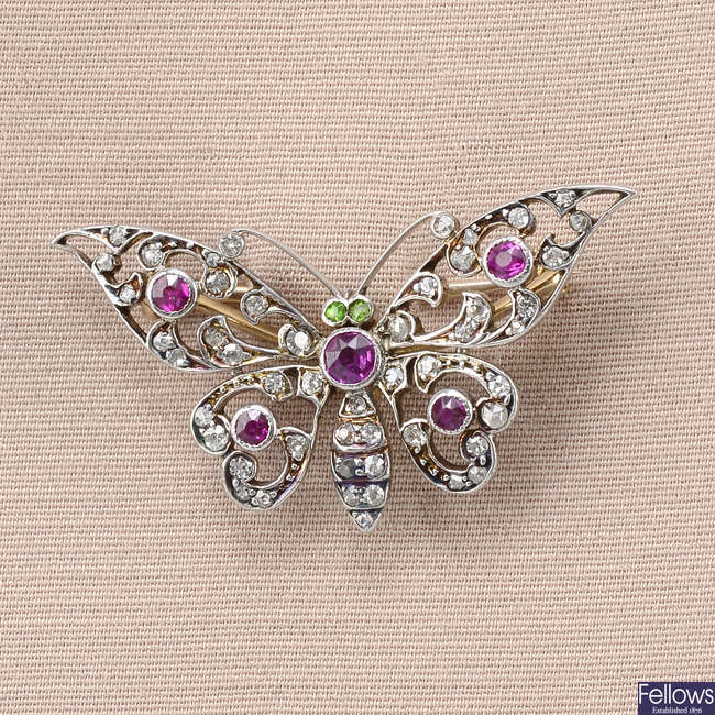An Edwardian gold, ruby and circular-cut diamond butterfly brooch, with demantoid garnet eyes.