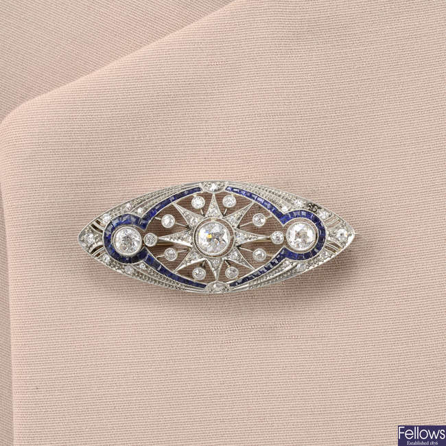 An old-cut diamond and calibre-cut sapphire openwork brooch.