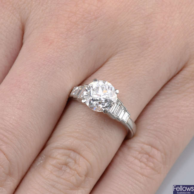 A platinum old-cut diamond single-stone ring, with baguette-cut diamond shoulders.