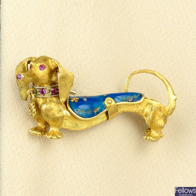 A mid 20th century gold dachshund dog brooch, with ruby and enamel highlights.