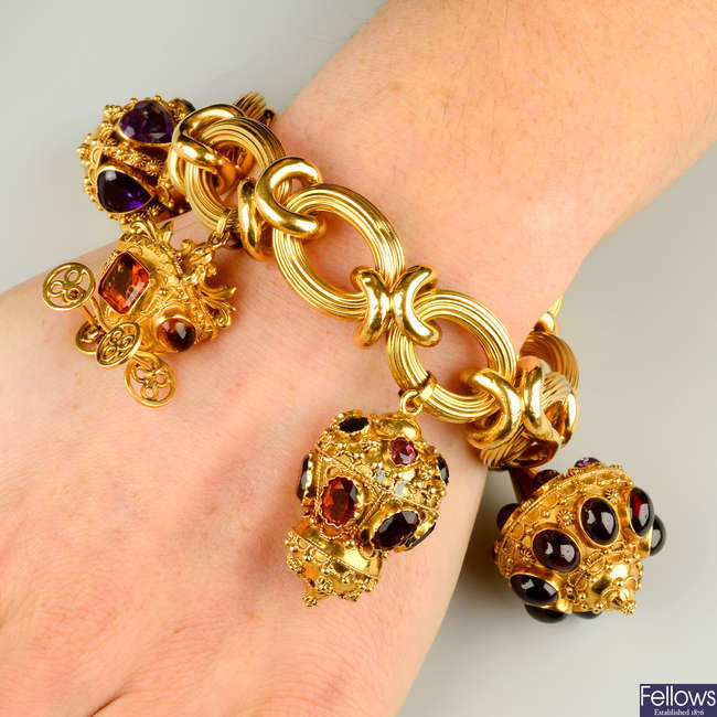 A mid 20th century 18ct gold bracelet, suspending four amethyst, citrine and gem-set charms, to include a carriage.