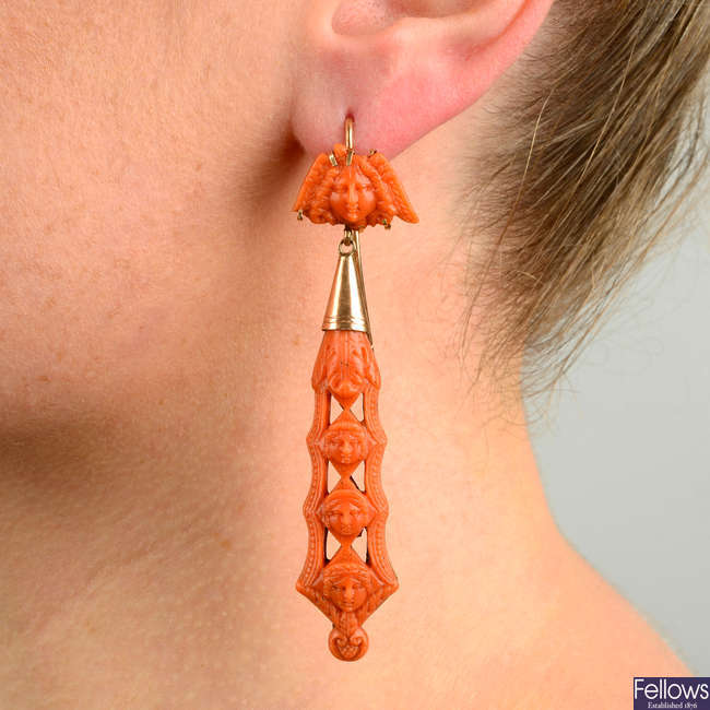 A pair of 19th century gold, figural and floral carved coral earrings, with winged medusa carved coral surmounts.
