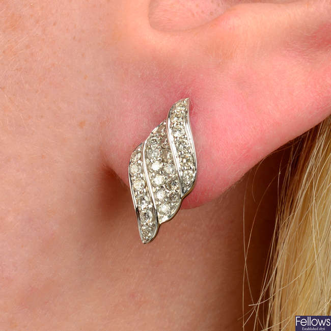 A pair of 18ct gold brilliant-cut diamond scroll motif earrings.