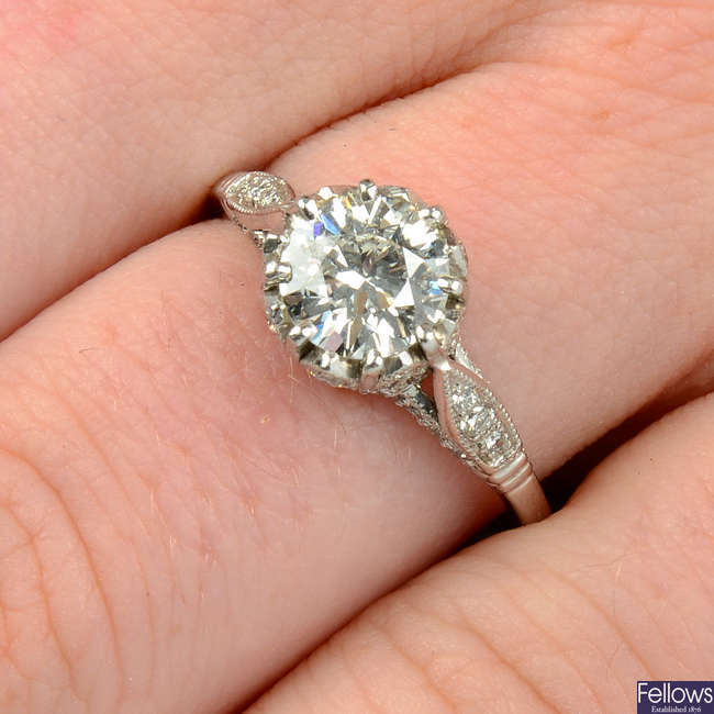 A brilliant-cut diamond single-stone ring, with pavé-set diamond gallery.