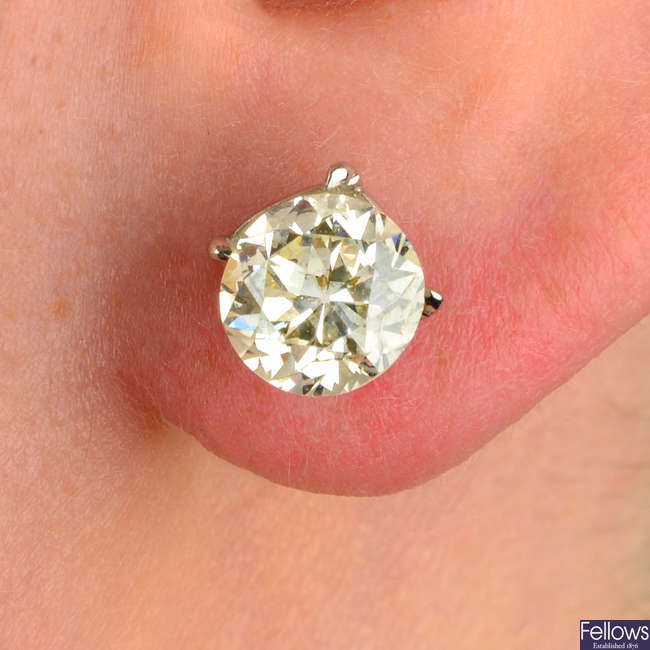 A pair of loose old-cut diamonds, with stud earring mounts.