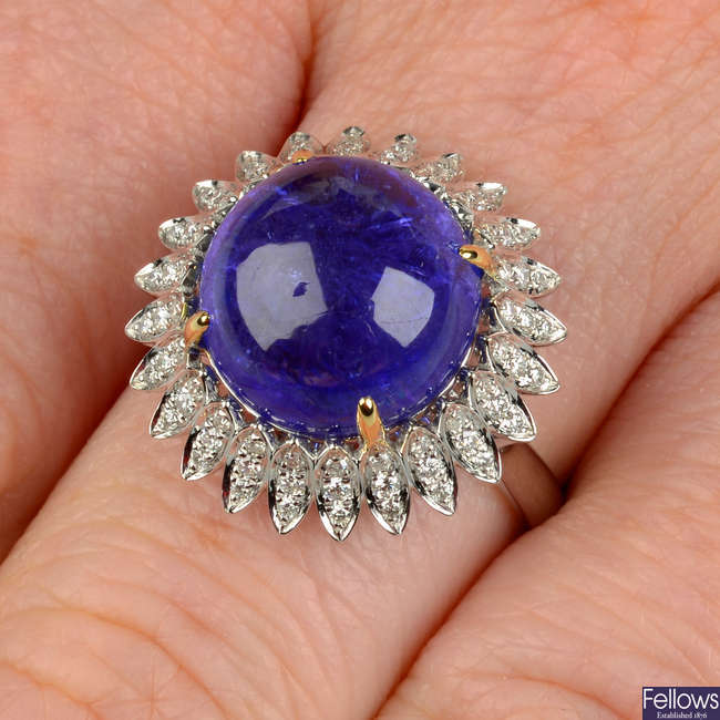 A tanzanite cabochon and diamond floral cluster ring.