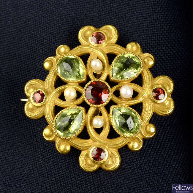 An early 20th century lightly textured 14ct gold garnet, peridot and seed pearl brooch.