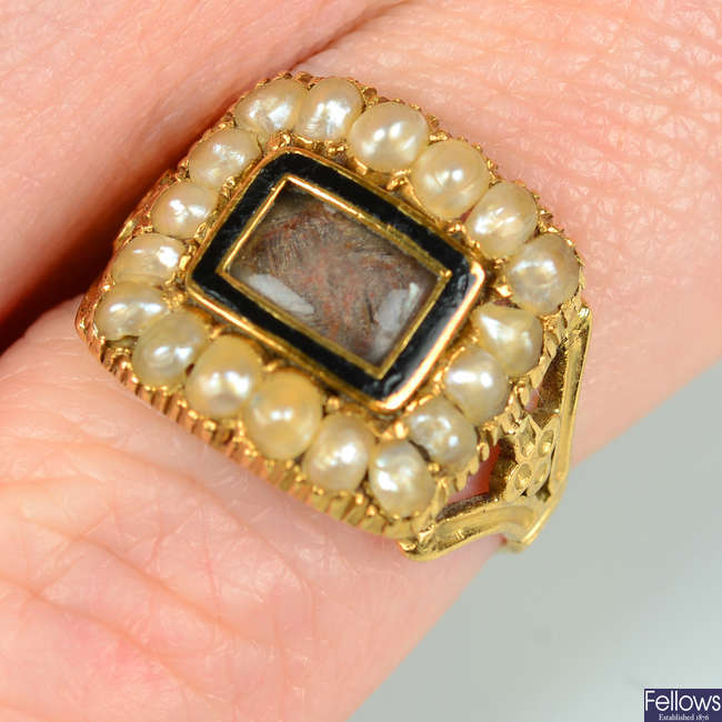 A late Georgian 18ct gold glazed woven hair memorial ring, with black enamel and split pearl surrounds.
