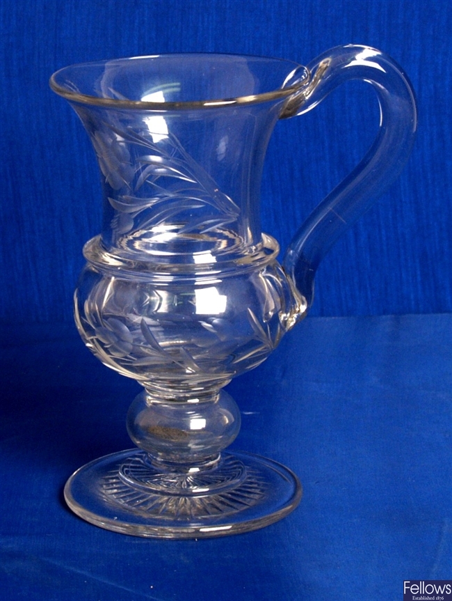 An antique glass, with looped handle, floral
