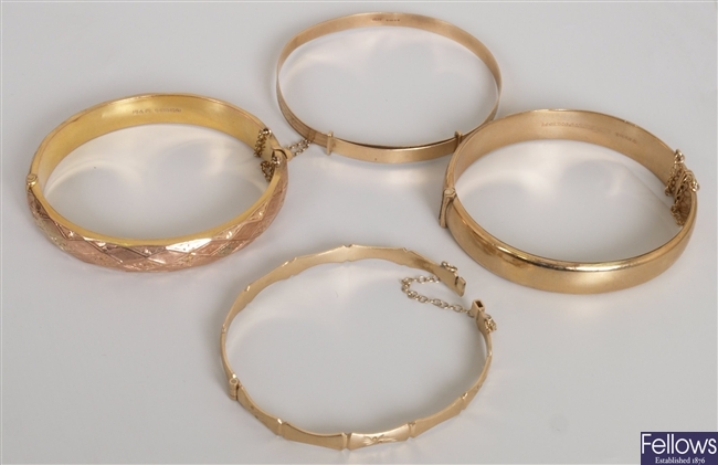 Four 9ct gold bangles to include a textured