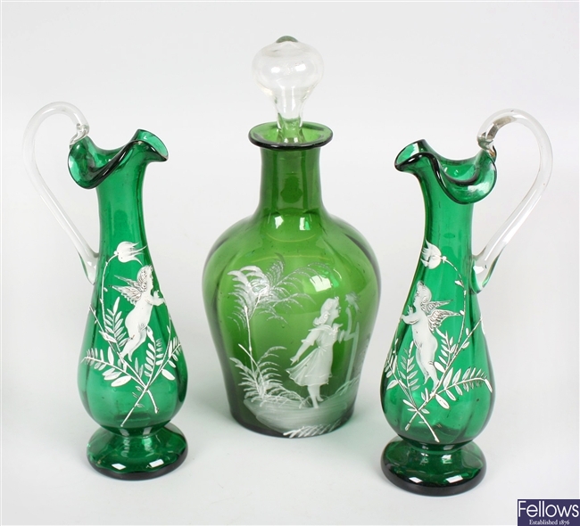 A pair of late 19th century green glass ewers and a similar bottle with stopper
