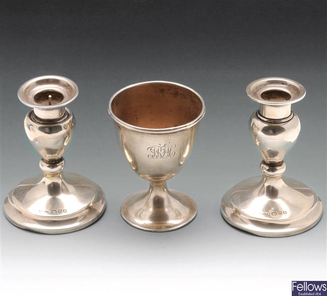 Pair of silver candlesticks and egg cup.