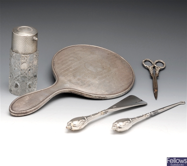 Silver hand mirror and dressing table items.
