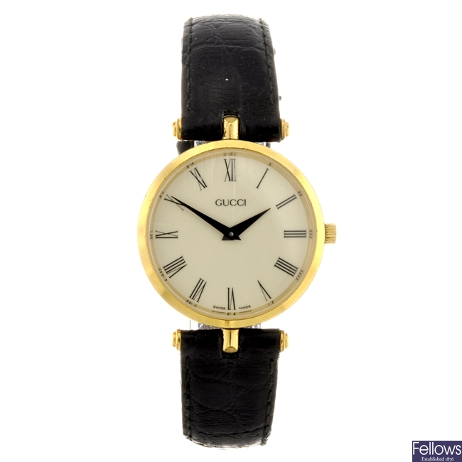 A gold plated quartz gentleman's Gucci wrist watch with two Gucci watch heads.