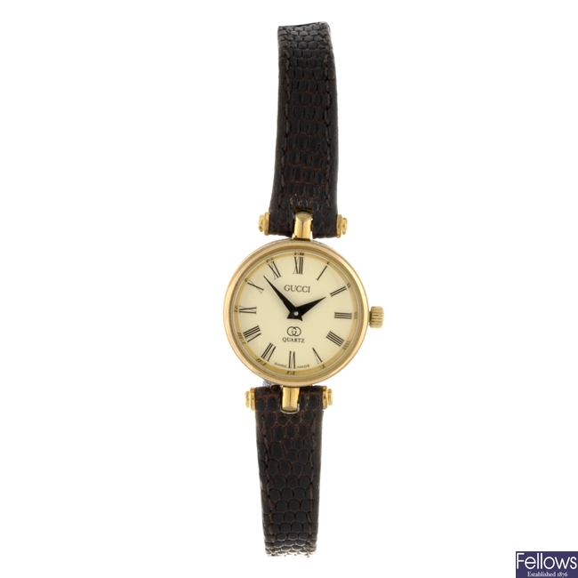 A gold plated quartz lady's Gucci wrist watch with two others.