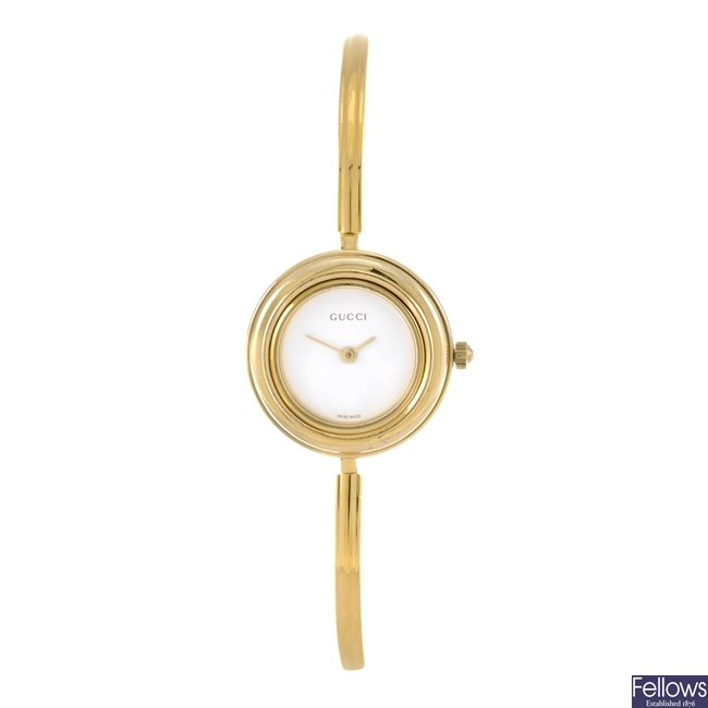 A gold plated quartz lady's Gucci bangle watch.