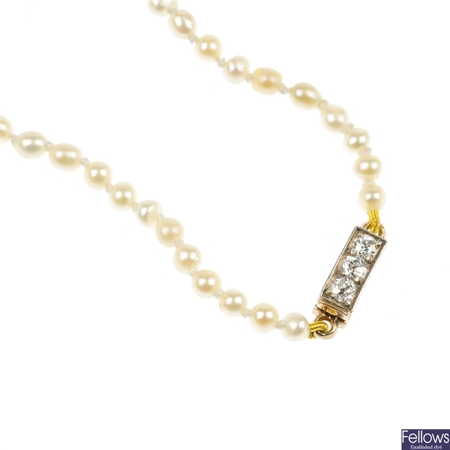 An early 20th century natural pearl necklace with diamond clasp.